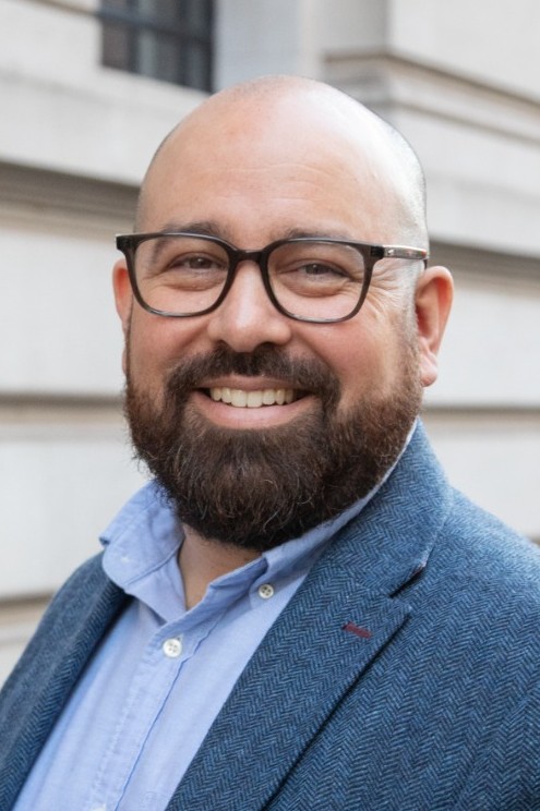 Man with a beard wearing glasses smiling