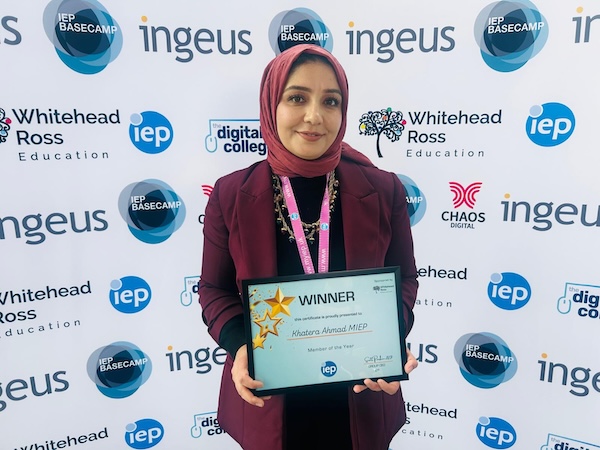 lady in headscarf holding a winner award